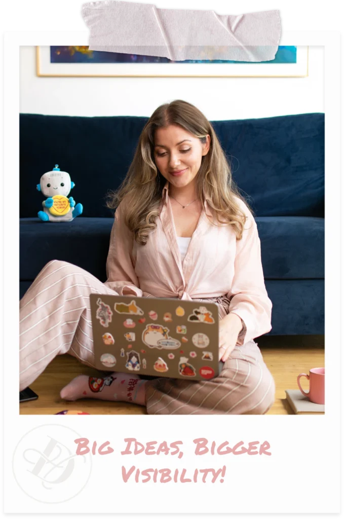 Woman sitting on the floor and typing on laptop, dressed in a light pink blouse and striped trousers