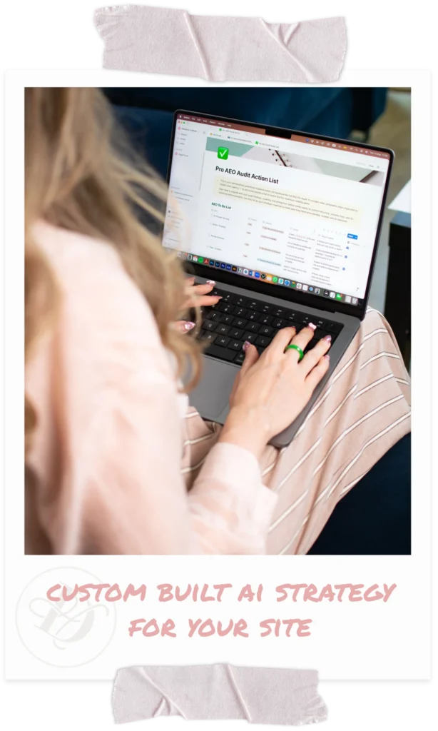 Woman wearing pink shirt seen from over shoulder, typing on laptop